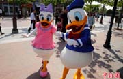 上海ディズニーのプレオープン、キャラクターと觸れ合う観光客