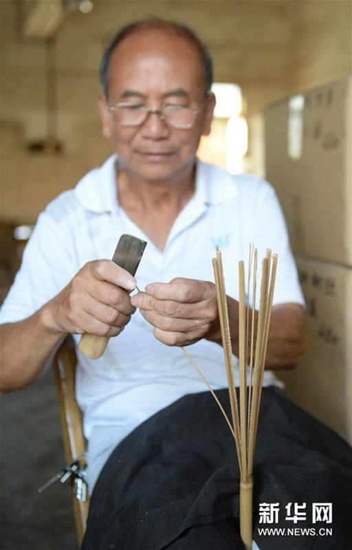 うちわの骨組みを作る広西チワン族自治區(qū)桂林市霊川県のうちわ職人?黃碩夫さん（7月6日撮影）。