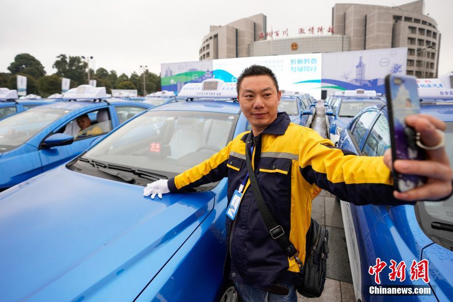 引き渡しセレモニーでメタノール車タクシーと記念撮影するタクシー運転手（撮影?賀俊怡）。