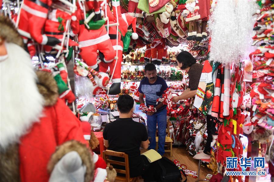 6月26日、義烏國際商貿城のある店でクリスマスグッズを仕入れるインド人バイヤー（寫真中央、撮影?黃宗治）。