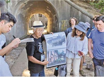 大久野島で毒ガス製造に関する歴史を説明する山內さん(左から2番目) （撮影?劉軍國）。