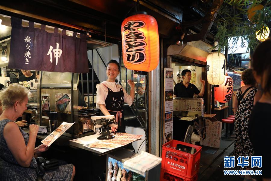 東京の新宿で13日夜、客に聲をかける店主（撮影?杜瀟逸）。