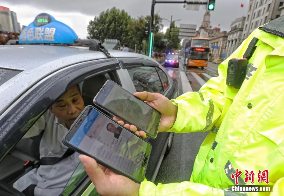  ドライバーの電子版運転免許証を確認する警察官 (撮影?殷立勤)。