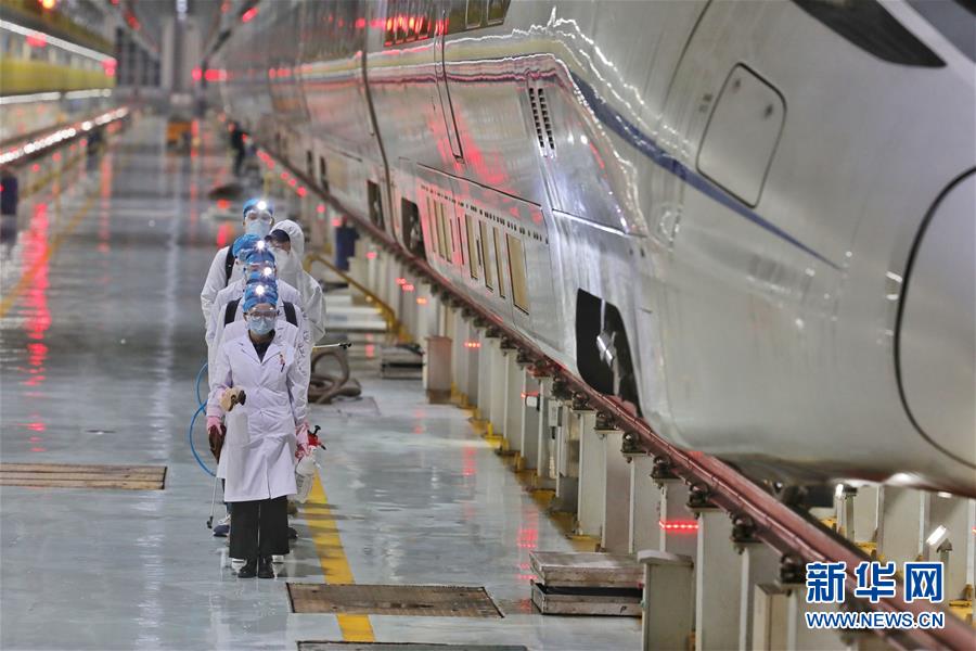 2月2日、高速列車の傍を通りながら消毒?防疫作業を行う作業員（撮影·歐東衢）。