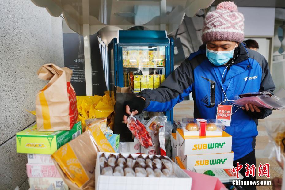 2月27日、スイーツを取るデリバリー配達員の男性（撮影?殷立勤）。