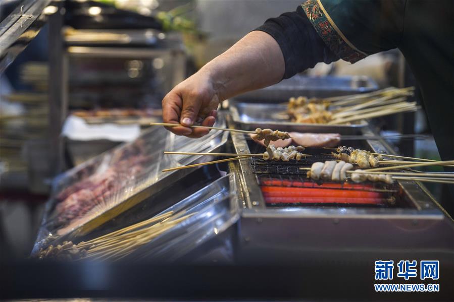 3月16日、ホータンナイトバザール環(huán)湖店で、串焼きを作る屋臺の店主（撮影? 趙戈）。