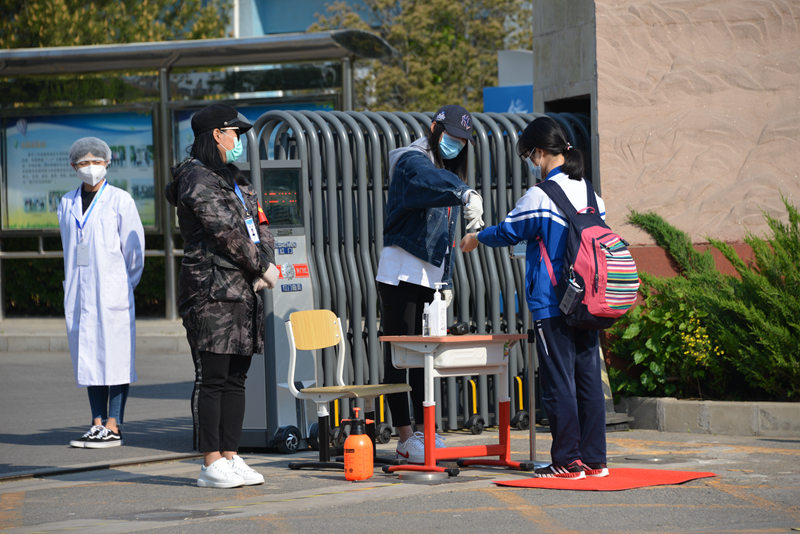 資料寫真、北京市昌平二中回竜観キャンパスの校門で體溫測定を受ける學生（畫像提供?北京教育ニュースセンター）。