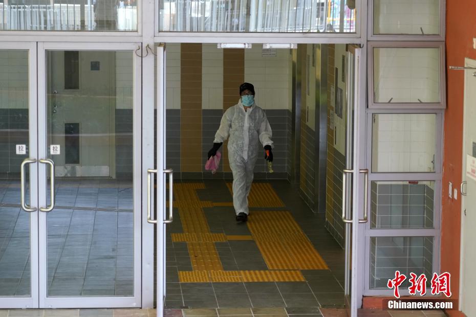 7月11日、防護服を著用して香港地區沙田にある水泉澳邨明泉樓の內部を消毒する作業員（撮影?張煒）。