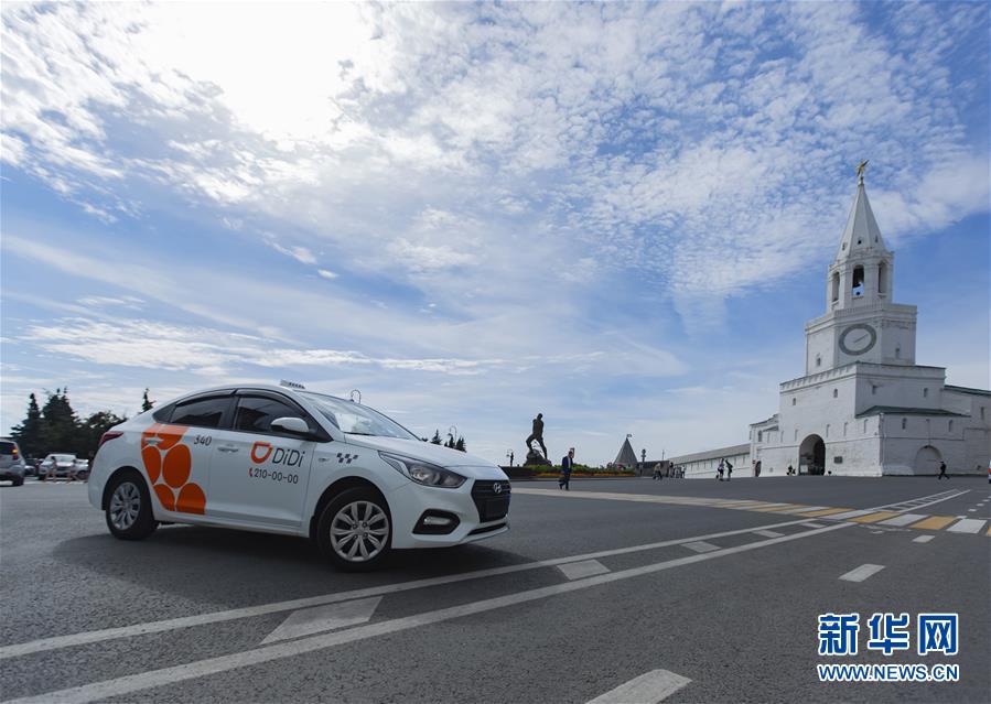 24日、ロシアのカザン?クレムリン前に停車する「滴滴」の車両。 