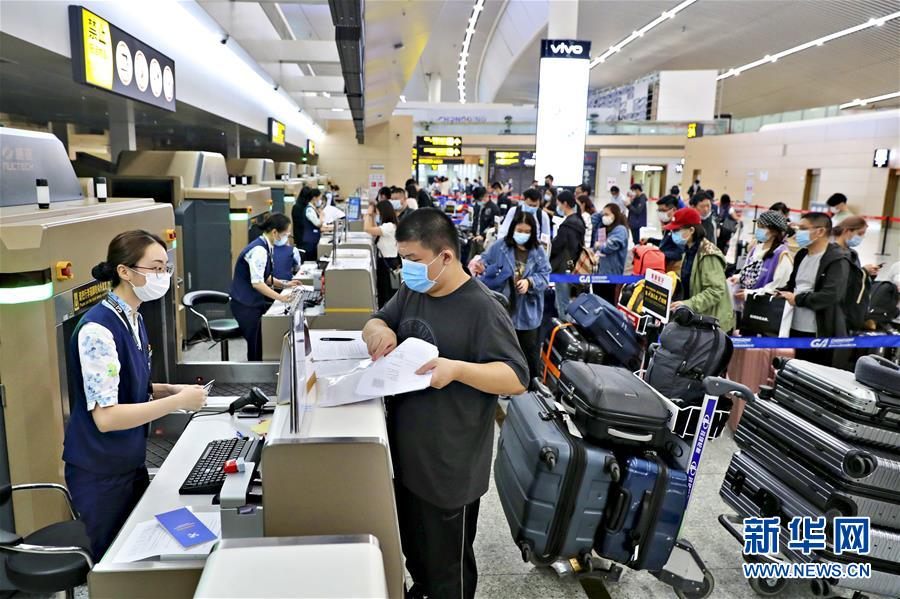 9月21日、海南航空が運航する英國行チャーター機HU7953便に搭乗するため、重慶江北國際空港ターミナルビルの指定エリアでチェックイン手続きをする留學生たち（畫像提供?重慶空港集団）。