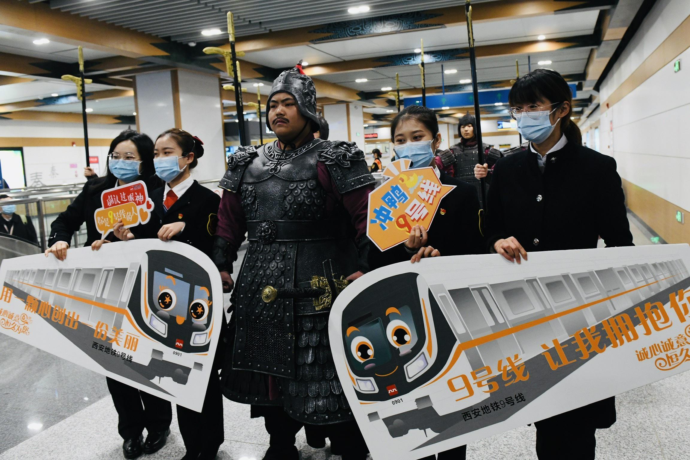 12月9日、秦陵西駅で、地下鉄アテンダントたちと記念撮影する「兵馬俑」（寫真著作権はCFP視覚中國が所有のため転載禁止）。