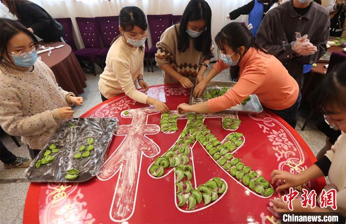 包んだ餃子で文字を作る大學生（撮影?泱波）。