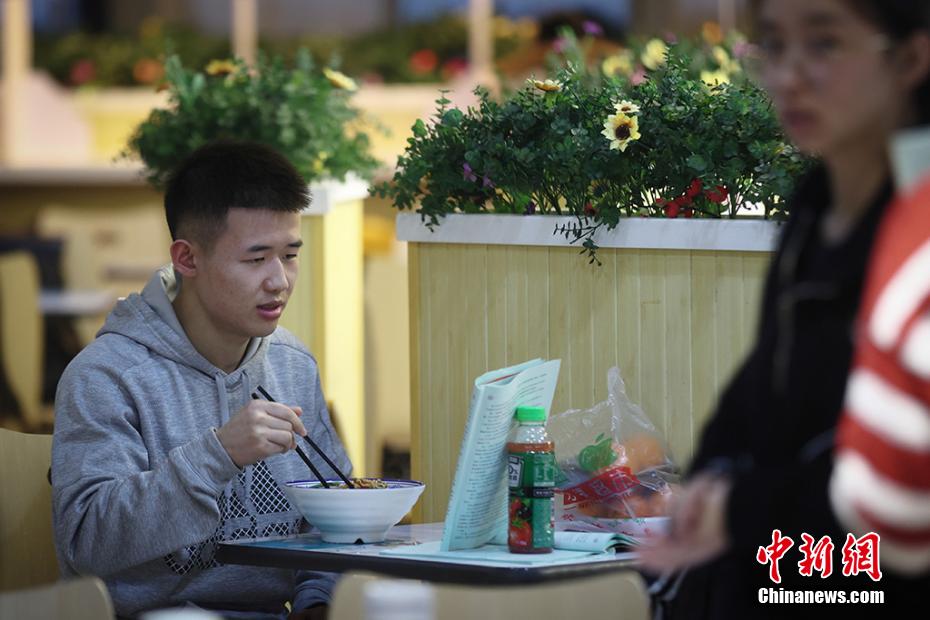 麺料理を食べながらも復(fù)習(xí)を続ける學(xué)生（撮影?泱波）。