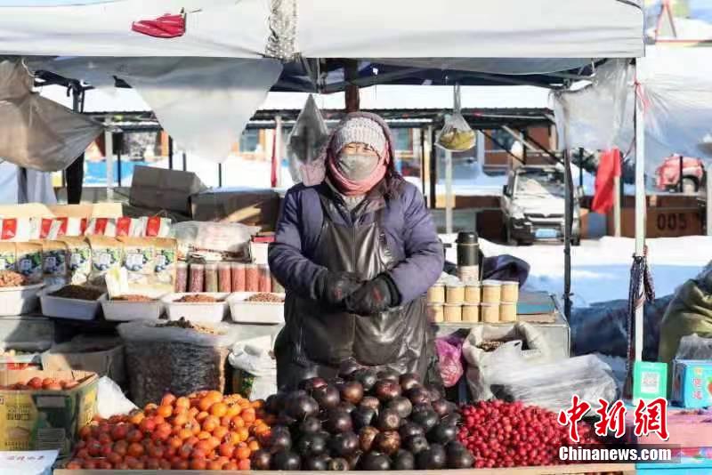 しっかり著込んで東北名物の凍果を売る漠河市の露店経営者（撮影?王景陽）。