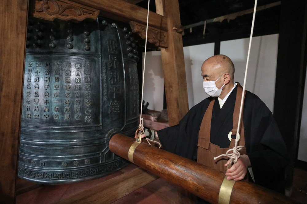 2月26日、長崎興福寺で、「世界平和の鐘」の試し突きをする松尾法道住職（撮影?杜瀟逸）。