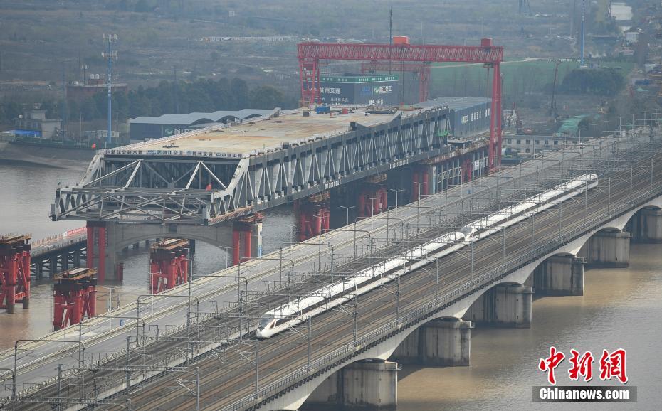 3月4日、銭塘江に新たに建設(shè)されている大橋の傍を走り抜ける高速鉄道（撮影?王剛）。