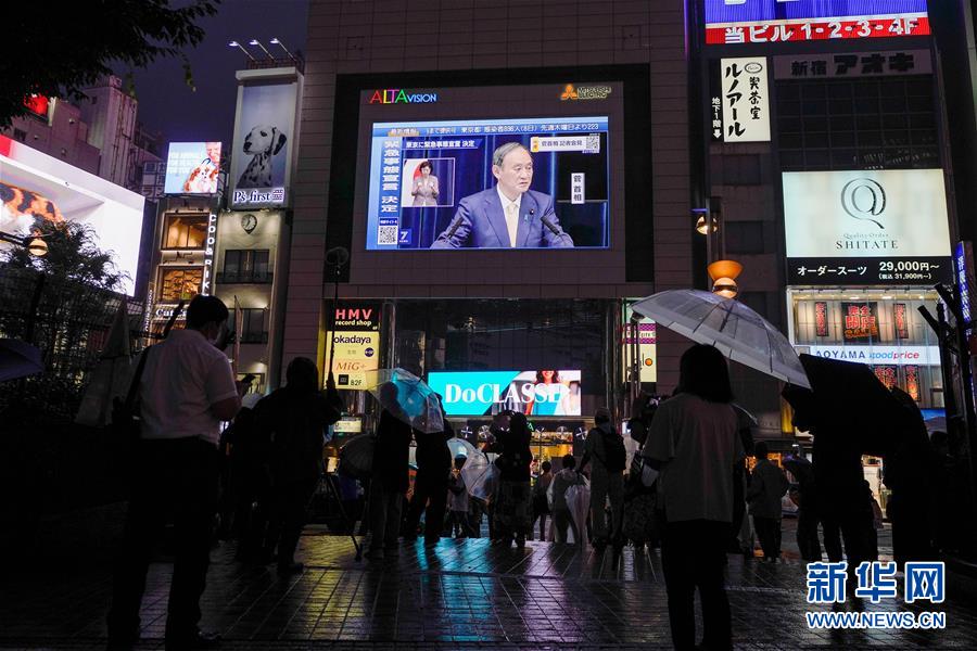 7月8日、日本の東京で、菅義偉首相が緊急事態宣言の発令を表明した記者會見の様子を映し出す街頭スクリーン。