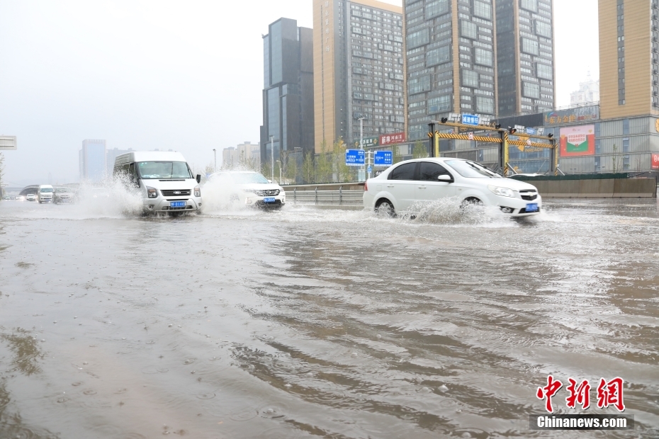 鄭州市市街地で、冠水した道路を走行する車両（撮影?闞力）。