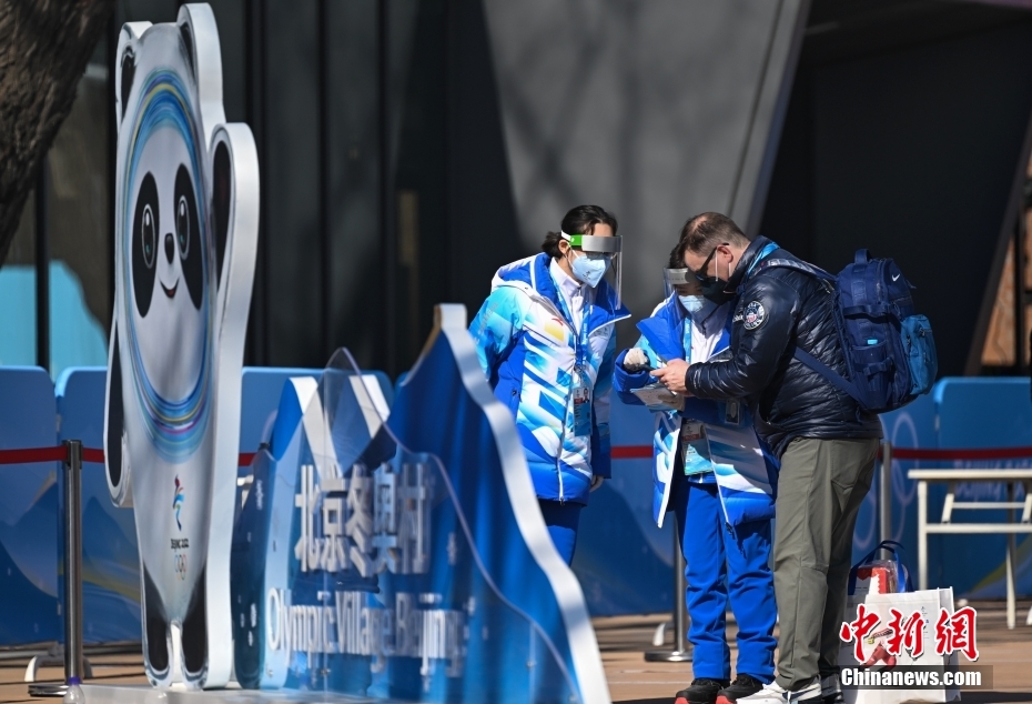 北京冬季五輪選手村のゲストにガイダンスを行うボランティア（寫真左、1月29日撮影?何蓬磊）。