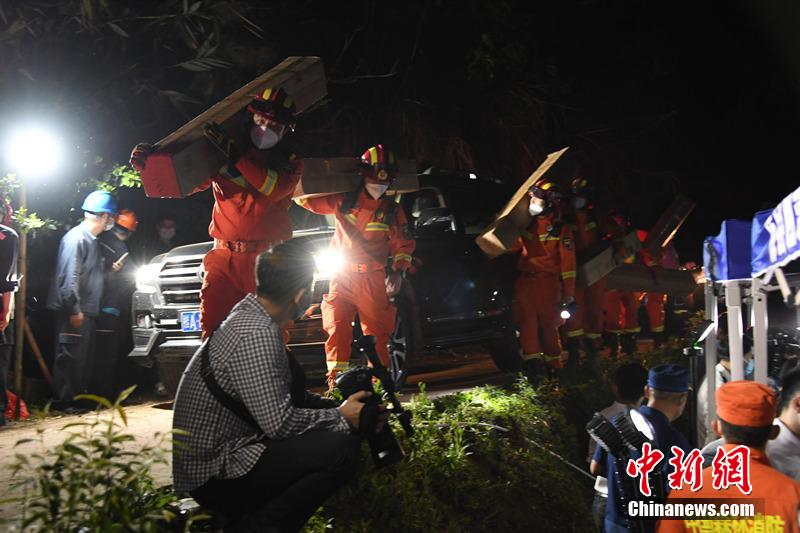 3月21日夜、事故機(jī)の墜落現(xiàn)場(chǎng)で、臨時(shí)指揮部を立ち上げた救助チーム。現(xiàn)地の電力供給當(dāng)局は、野外用臨時(shí)電線(xiàn)を架設(shè)して救助活動(dòng)をサポート。消防隊(duì)員が運(yùn)搬した救援物資も事故現(xiàn)場(chǎng)に到著（撮影?何華文）。