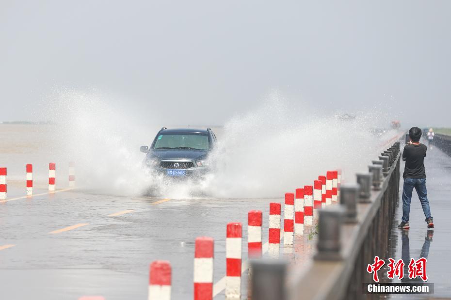 大きな水しぶきをあげながら「水上道路」を走行する自動車（撮影?劉力鑫）。