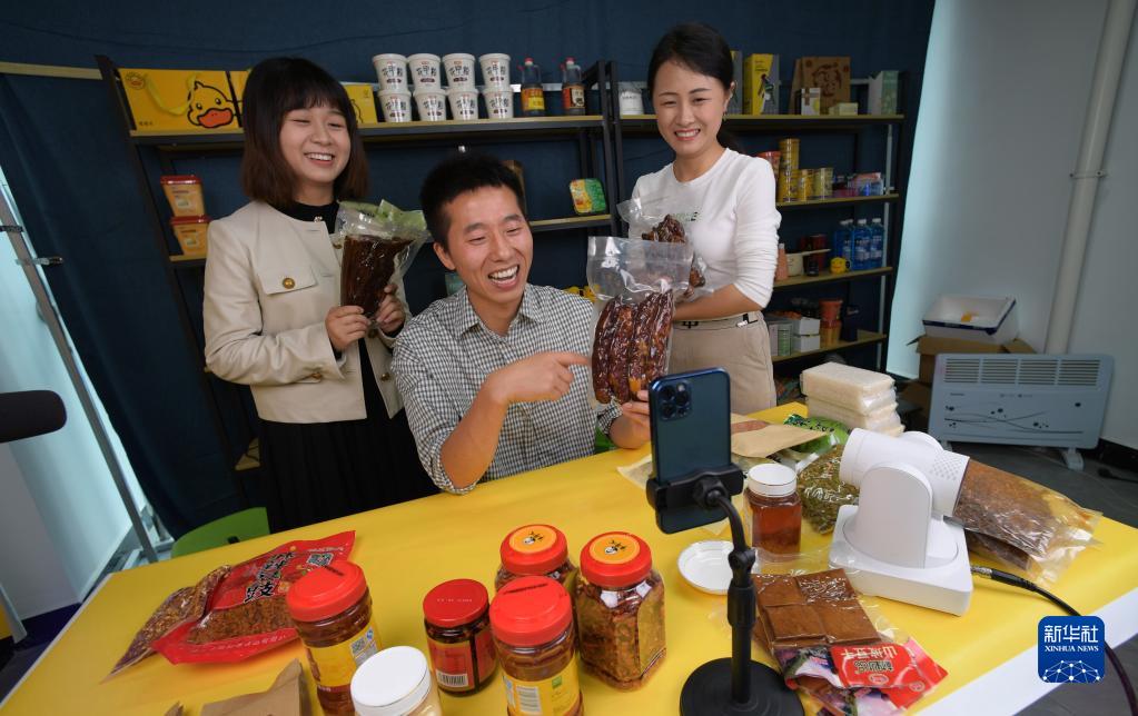 貴州省順義市綏陽県農産物流通センターで、ライブコマースを通じてソーセージを販売する蔣栄慶さん（寫真中）とスタッフ（6月12日撮影?楊楹）。