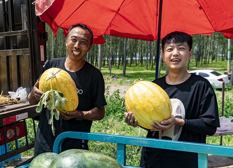 黃色いスイカを見せる農(nóng)家（寫真著作権はCFP視覚中國が所有のため転載禁止）。