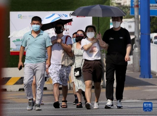 7月10日、炎天下の中、上海市閔行區內を歩く市民。