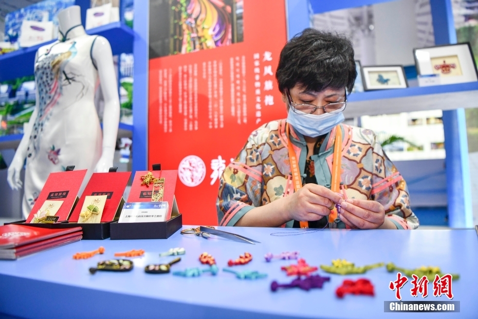 上海館に設(shè)けられた中國の老舗チャイナドレスブランド「竜鳳旗袍」展示ブースで、チャイナドレスのボタンの制作技法を披露する無形文化遺産伝承者（撮影?駱雲(yún)飛）。