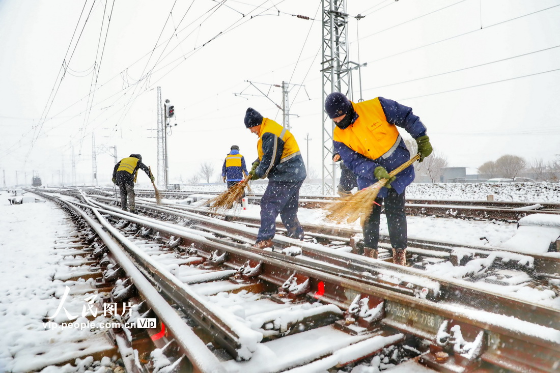 鉄道輸送の安全性と円滑性を確保するため、分岐器の除雪作業を行う中國鉄路瀋陽局集団公司の職員（11月12日撮影?李季春/寫真著作権は人民図片が所有のため転載禁止）。