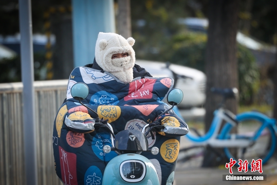 強風の中、電動バイクで外出する市民（撮影?賈天勇）。