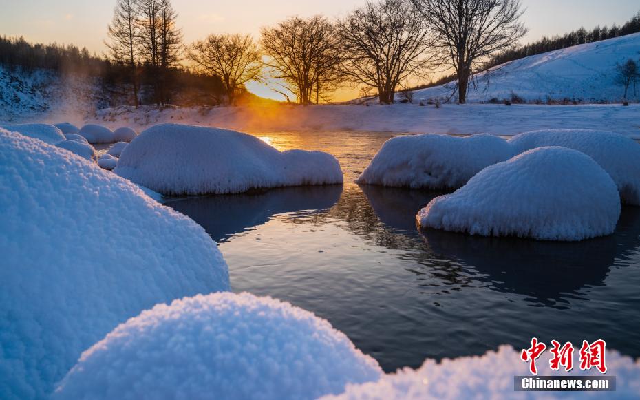 「凍らない川」に浮かぶ、真っ白で餅のようにこんもりとした雪の塊（撮影?李明）。