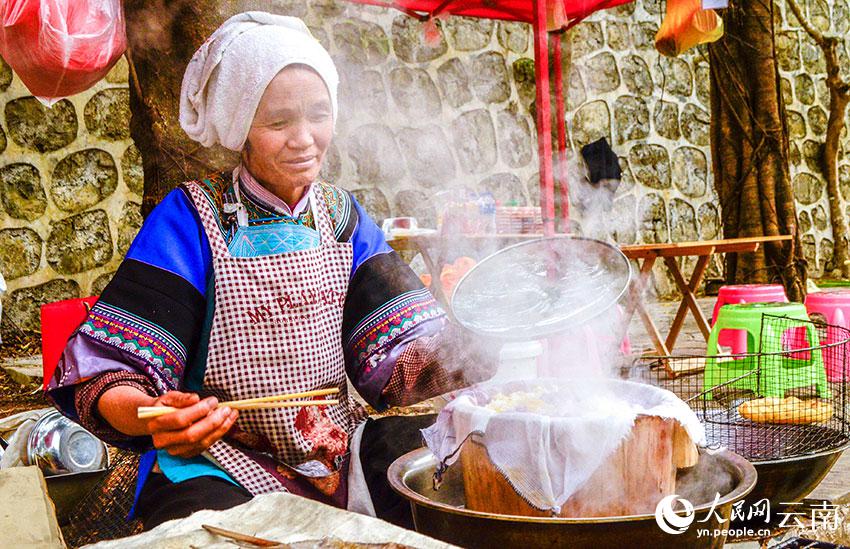 多依河のほとりで布依族の特色豊かなグルメ「花米飯」を作り、販売する布依族の女性（撮影?劉怡）。