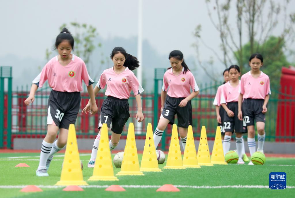 四川省広安市管轄下の華鎣市にある雙河第三小學校のサッカーグラウンドで練習に勵む女子サッカークラブの選手たち (4月13日撮影?邱海鷹）。