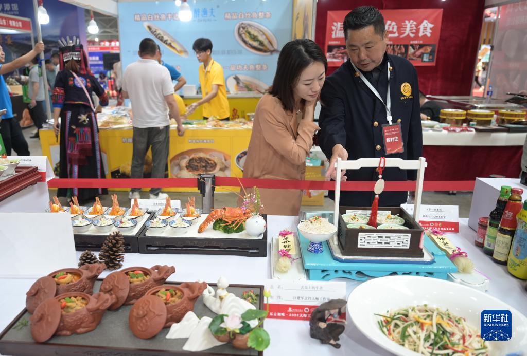 來(lái)場(chǎng)者に料理について紹介する有名シェフの楊俊さん（寫真右、5月18日撮影?林善伝）。