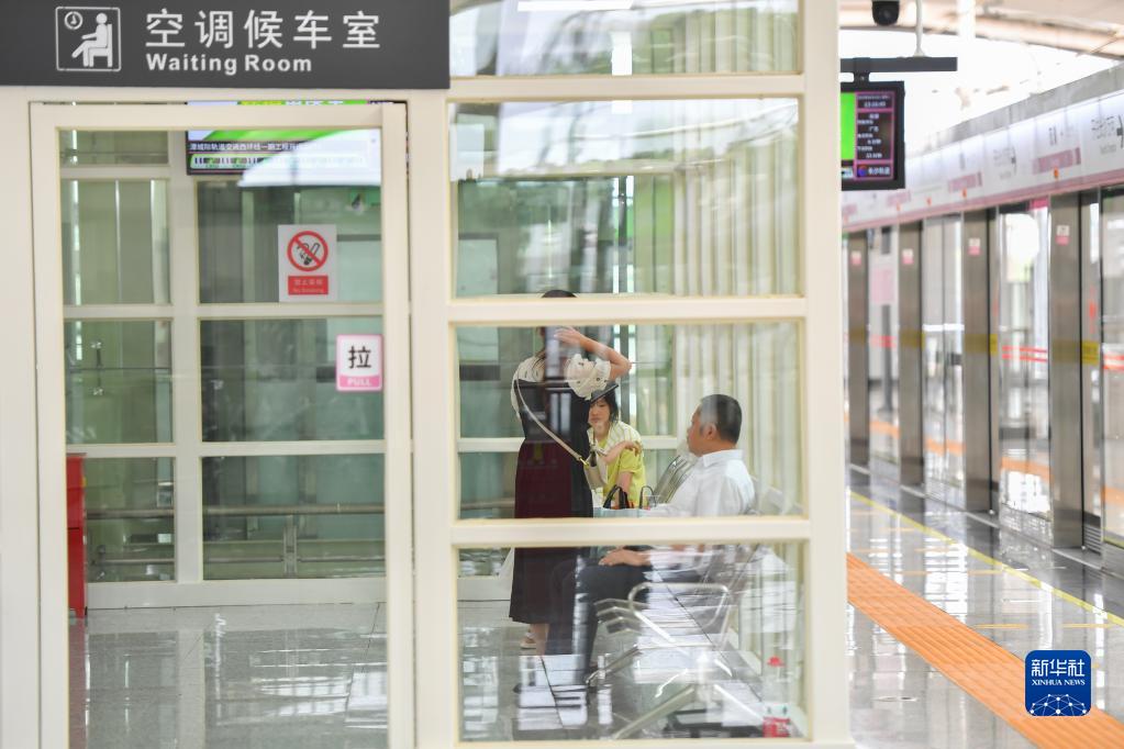 開業(yè)した長株潭都市間鉄道西環(huán)線第一期プロジェクトの雙湖駅にあるエアコン付きの待合室で電車の到著を待つ乗客（6月28日撮影?陳澤國）。