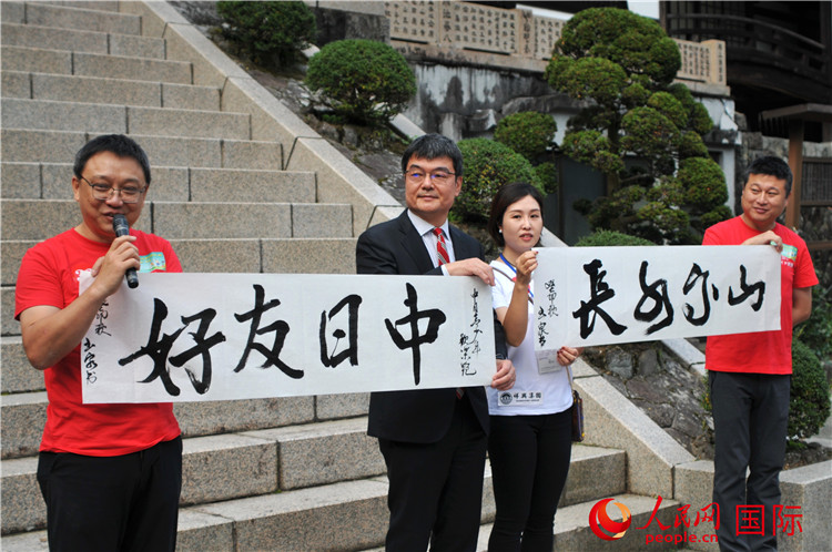 今回のイベントのために書き上げた「中日友好、山高水長」という書道作品を披露する中國文化センターの羅玉泉センター長（撮影?蔣暁辰）。