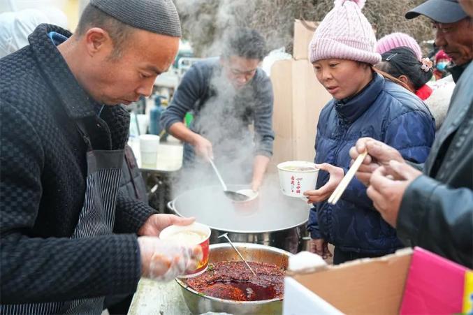 避難所の炊きだしでラーメンを提供する男性たち（撮影?賀勇）。