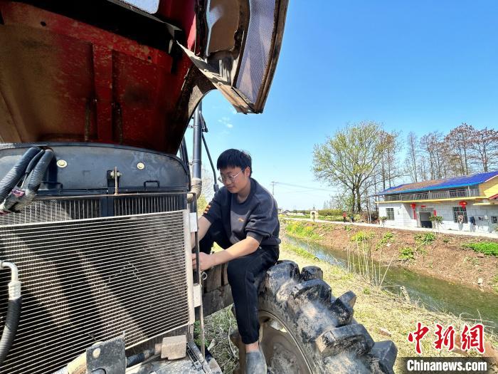 3月28日、自宅のエビ養(yǎng)殖水田で農(nóng)業(yè)機械の點検整備を進めている00後（2000年代生まれ）の虢宇さん。（撮影?曹盈）