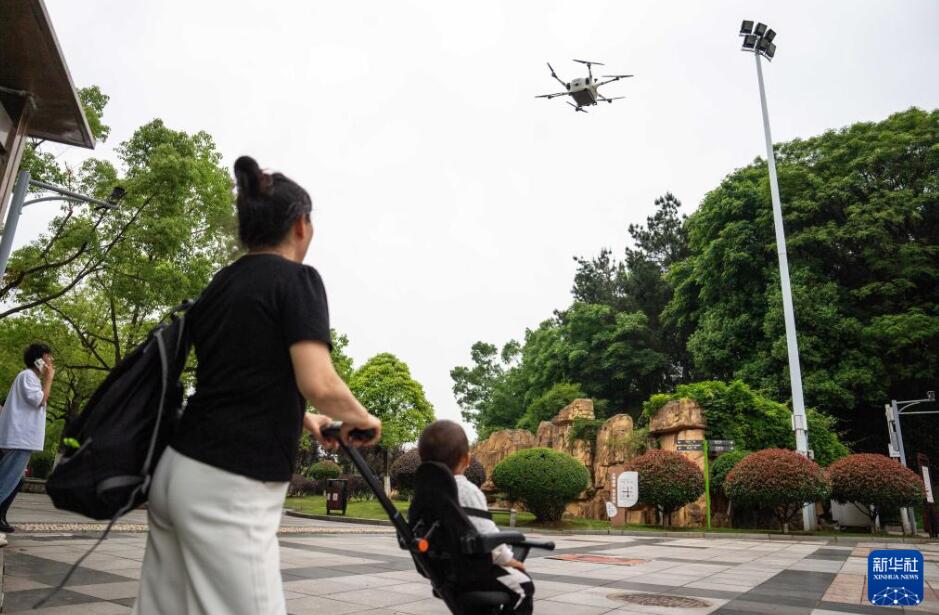 湖南省長沙県の市街地にある公園で、荷物を積んだドローンが著陸する様子を見守る市民（5月7日撮影?陳思汗）。