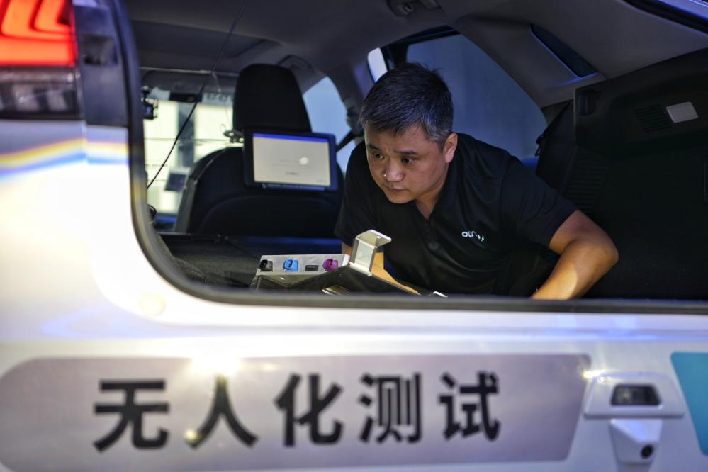 自動運転テスト車両の車內に搭載されている設備を検査する王偉さん（6月19日撮影）。